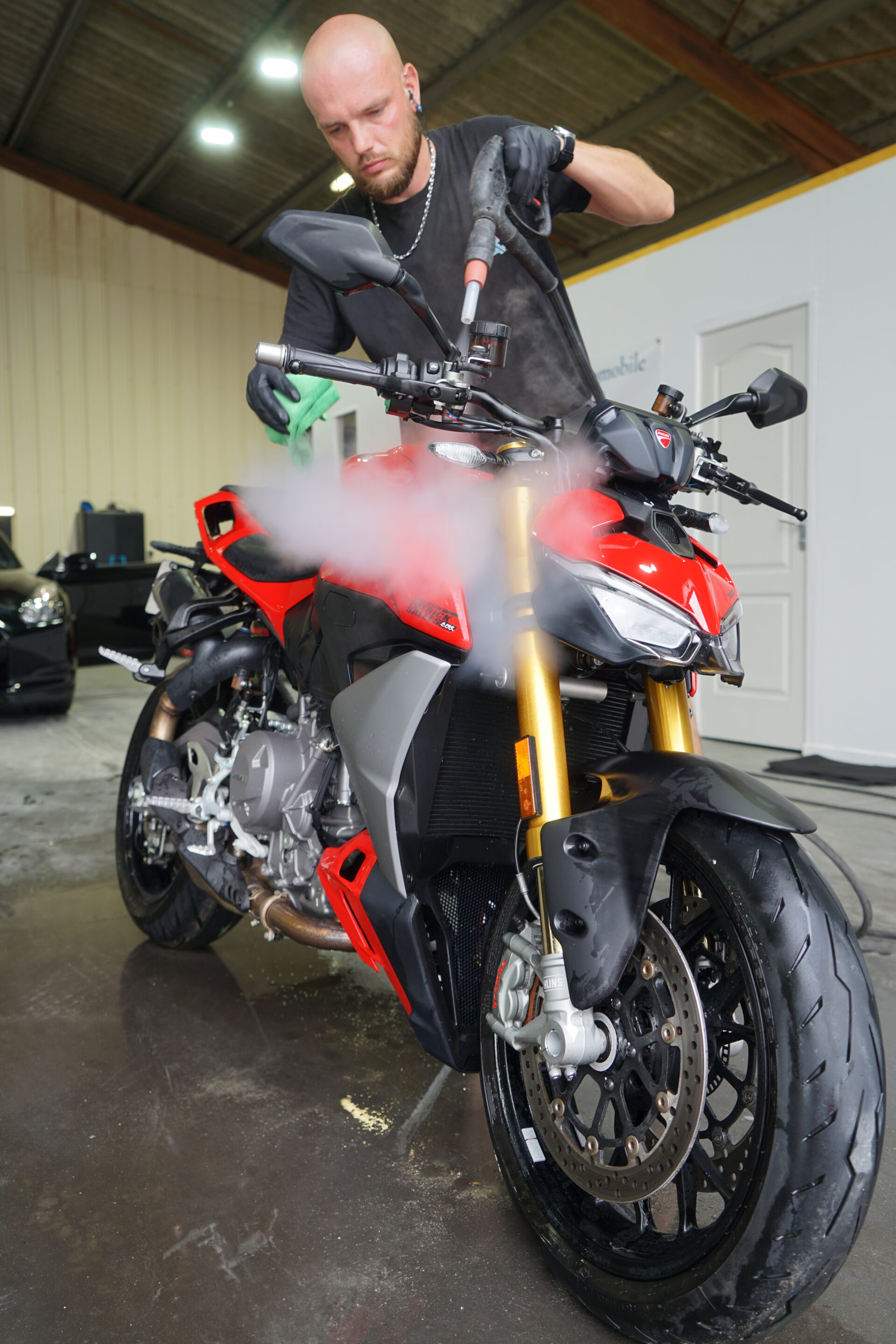 Ducati rouge vue de trois quarts pendant son nettoyage à la vapeur chez Antunes Carro Limpo